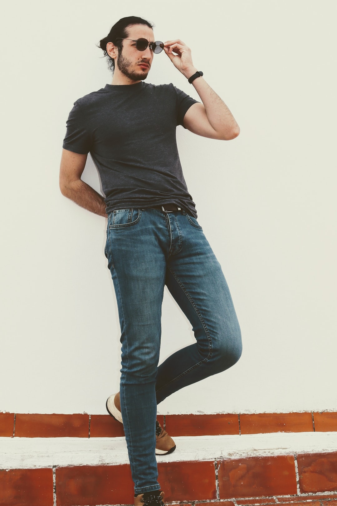 man in black crew neck t-shirt and blue denim jeans