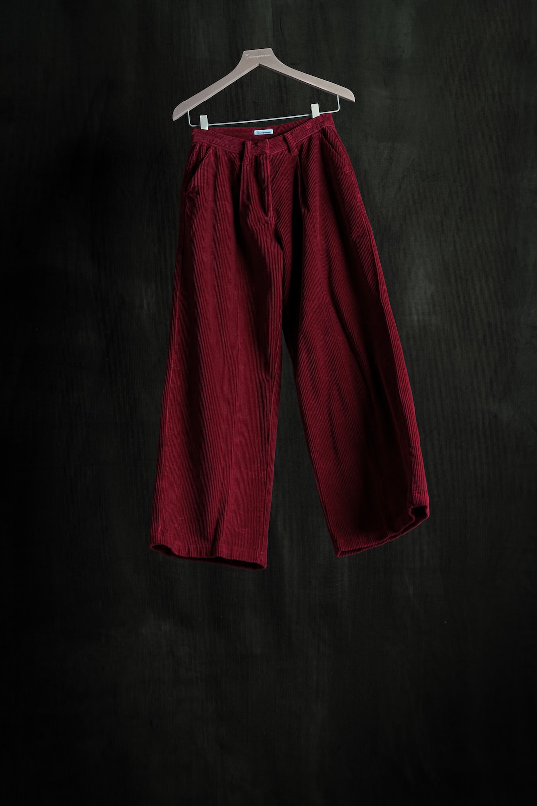 a pair of red pants hanging on a hanger