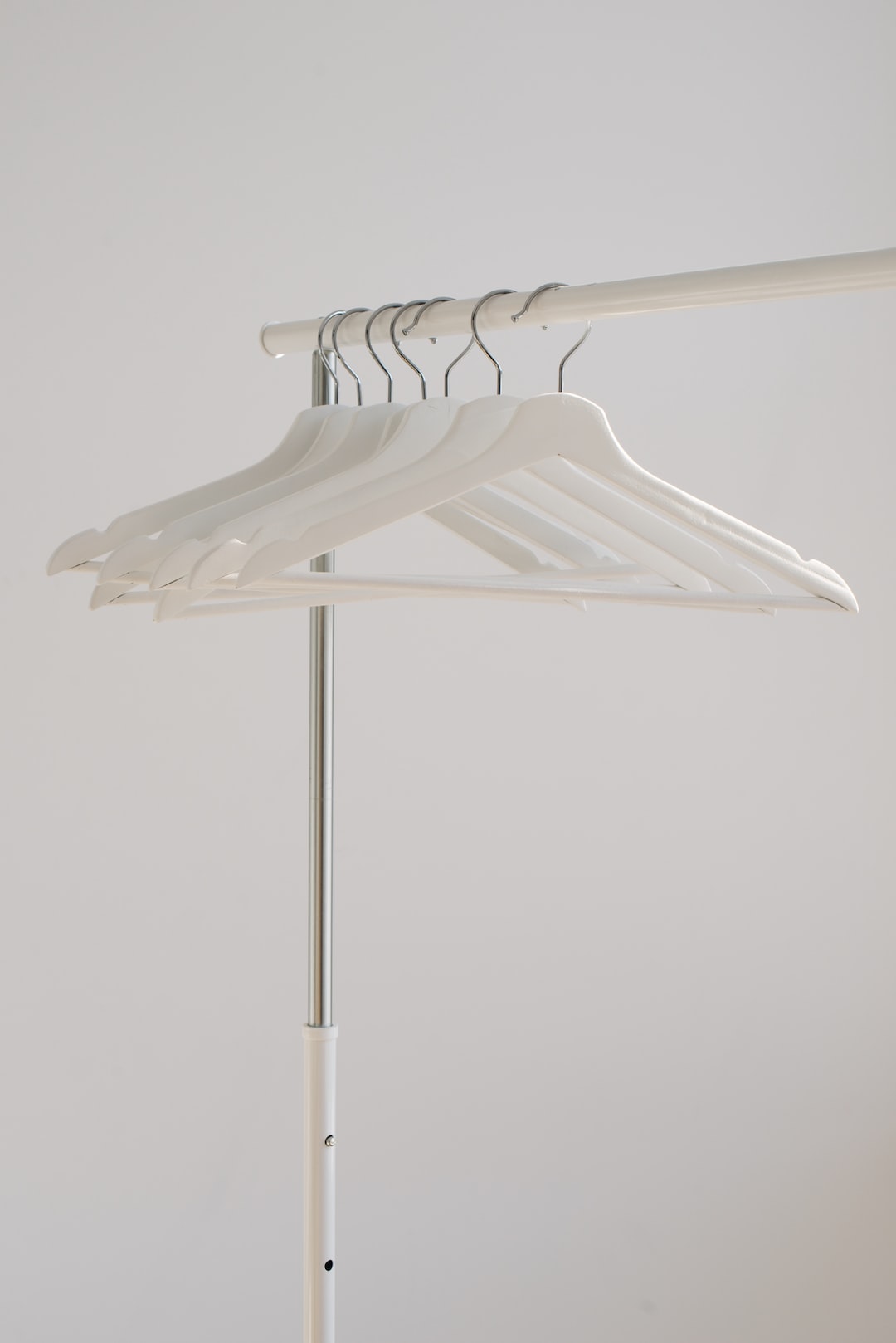 white clothes hangers hanging on rack