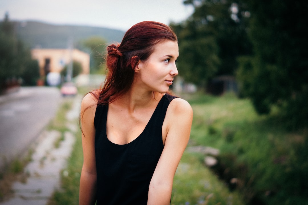 depth of field photography of woman in black tank top on street