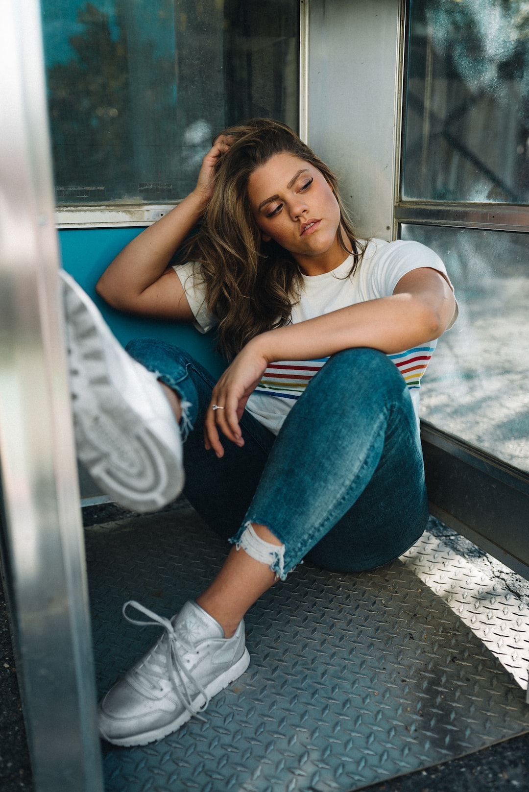 woman in white t-shirt and blue denim jeans sitting on train seat
