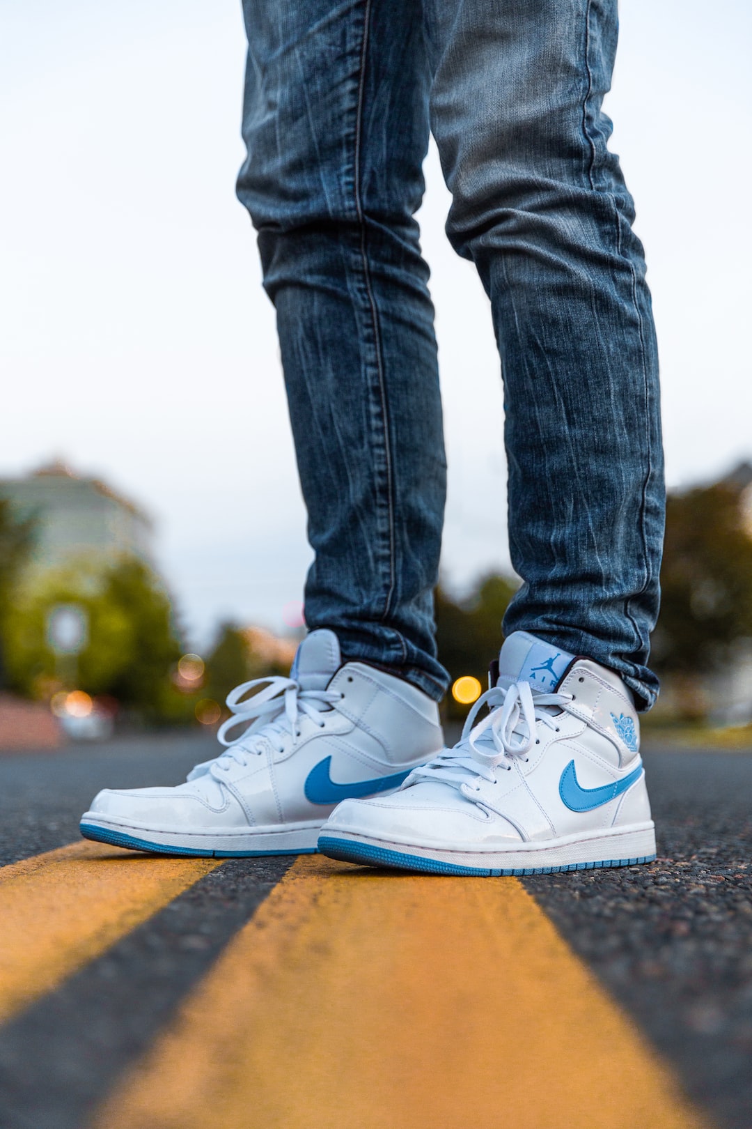 selective focus photography of person wearing blue-and-white Nike Air Jordan 1's