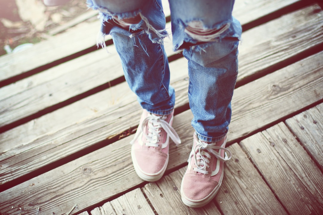 person in blue denim jeans and brown and white sneakers